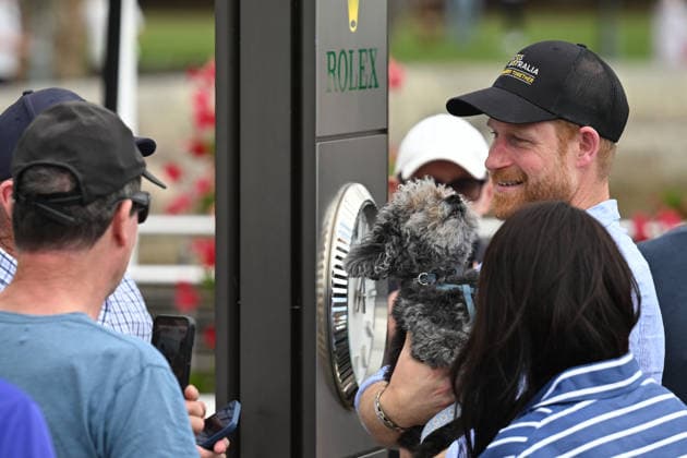HARRY AND MEGHAN AUSTRALIA VISIT, Prince Harry holds a small dog as he walks with wife Meghan, the Duke and Duchess of Sussex at the Cruising Yacht Club of Australia after sailing on Sydney Harbour with Invictus Australia during a visit to Australia, Sydney, Friday, April 17, 2026. ( NO ARCHIVING SYDNEY NEW SOUTH WALES AUSTRALIA  Copyright: xDEANxLEWINSx 20260417168239635850