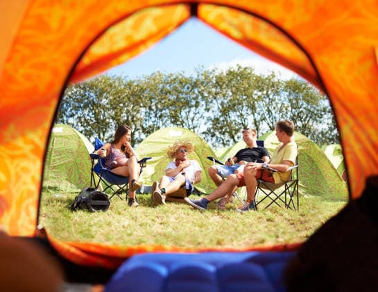 Shot of a group of friends sitting outside their tent at a festival. (License=RF) ,model released, Symbolfoto  Copyright: xZoonar.com KasperxRavlox 18561629 ,model released, Symbolfoto ,property released