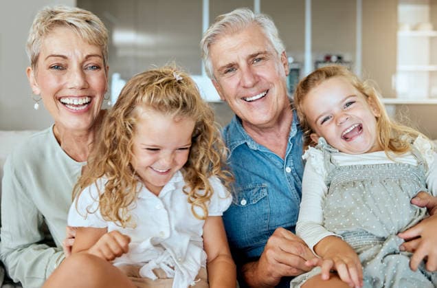 A happy caucasian mature couple bonding with their adopted kids in the living room. Two sisters relaxing with their grandparents while taking selfies together at home. (License=RF) ,model released, Symbolfoto  Copyright: xZoonar.com YurixArcursxpeopleimages.comx 18804523 ,model released, Symbolfoto ,property released