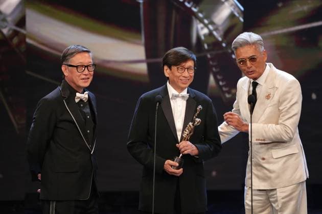 HONG KONG, CHINA - APRIL 19: Director Andrew Lau Wai-Keung (L), actor Chow Yun-fat (R) present the trophy to film producer and executive John Chu Ka-yan on the stage at the 44th Hong Kong Film Awards on April 19, 2026 in Hong Kong, China.  Copyright: xChinaxNewsxServicex 111635916368
