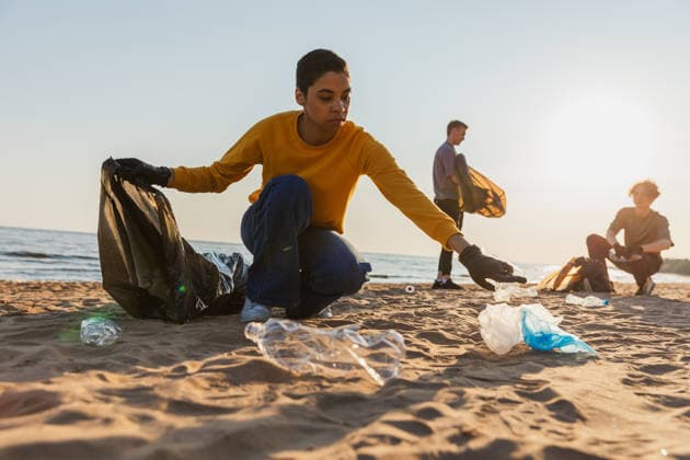 Tag der Erde. Freiwillige Aktivisten Team sammelt Müll Reinigung von Strand Küstenzone. Frau mans setzt Plastikmüll in Müllsack auf Ozean Ufer. Umweltschutz Küstenzone Reinigung. Earth day. Volunteers activists team collects garbage cleaning of beach coastal zone. Woman mans puts plastic trash in garbage bag on ocean shore. Environmental conservation coastal zone cleaning (License=RF) ,model released, Symbolfoto Copyright: xZoonar.com IuliiaxZavalishinax 24876432 ,model released, Symbolfoto ,property released