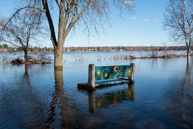 April 21, 2026, Fredericton, New Brunswick, Canada: A park bench sits surrounded by flood waters next to the walking and cycling trail along the Green, in Fredericton on Tuesday, April 21, 2026. The city closed parts of the trail due to the flood waters from the St. John River. Fredericton Canada  - ZUMAc35_ 20260421_zaf_c35_082 Copyright: xStephenxMacgillivrayx