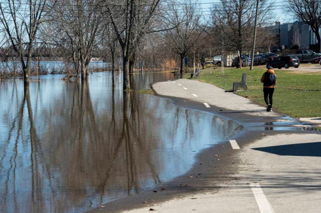 April 21, 2026, Fredericton, New Brunswick, Canada: A pedestrian diverts around the flood waters on the walking and cycling trail along the Green, in Fredericton on Tuesday April 21, 2026. The city closed parts of the trail due to the flood waters from the St. John River. Fredericton Canada  - ZUMAc35_ 20260421_zaf_c35_083 Copyright: xStephenxMacgillivrayx