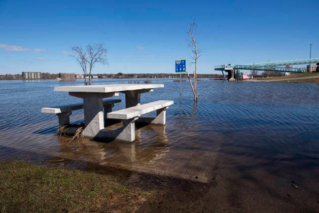 April 21, 2026, Fredericton, New Brunswick, Canada: A picnic table sits surrounded by flood waters next to the walking and cycling trail along the Green, in Fredericton on Tuesday, April 21, 2026. The city closed parts of the trail due to the flood waters from the St. John River. Fredericton Canada  - ZUMAc35_ 20260421_zaf_c35_084 Copyright: xStephenxMacgillivrayx
