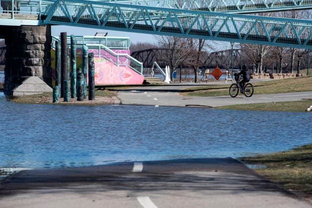 April 21, 2026, Fredericton, New Brunswick, Canada: A cyclist diverts around the flood waters on the walking and cycling trail along the Green, in Fredericton on Tuesday April 21, 2026. The city closed parts of the trail due to the flood waters from the St. John River. Fredericton Canada  - ZUMAc35_ 20260421_zaf_c35_085 Copyright: xStephenxMacgillivrayx