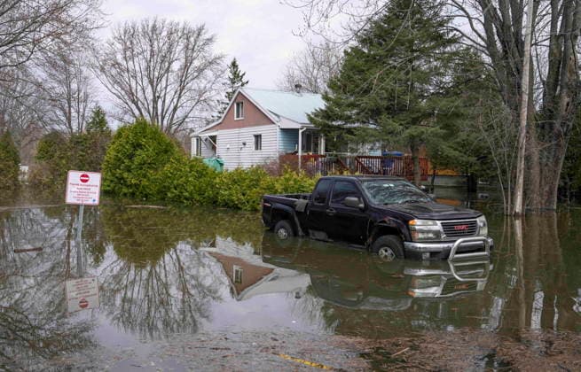 April 22, 2026, Rigaud, Pq, CANADA: A truck sits in flood water outside a home in Rigaud, Que., on Wednesday, April 22, 2026. Rigaud CANADA  - ZUMA Apr 20260422_zaf_c35_029 Copyright: xChristinnexMuschix