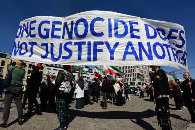 Gegner von Reza Pahlavi protestieren am Pariser Platz am Brandenburger Tor gegen den Besuch Pahlavis. Banner mit der Aufschrift One genocide does no justify another. Vor dem Reichstag versammelten sich zu selben Zeit Unterstützer Pahlavis. Protest gegen Reza Pahlavi *** Opponents of Reza Pahlavi protest against Pahlavis visit at Pariser Platz at the Brandenburg Gate Banner with the inscription One genocide does not justify another Supporters of Pahlavi protest against Reza Pahlavi gathered in front of the Reichstag at the same time
