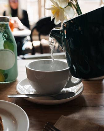 boiling tea pouring from a teapot in a cafe in England Sherborne, England, United Kingdom R_RABE260421D7-1991024-01 ,model released, Symbolfoto