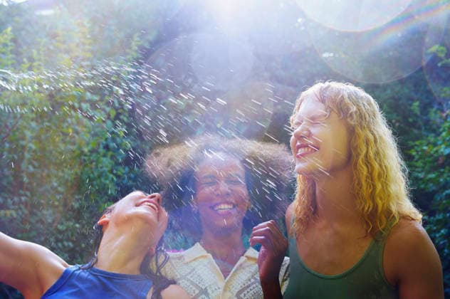 IMAGO Creative, Jahreszeit Sommer, Regen, Sommerregen Happy people enjoying water splash outdoors on a bright summer day model released, Symbolfoto, AZF00935