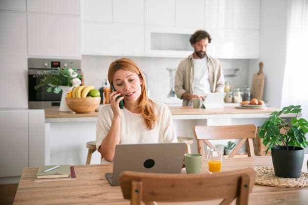 Wife working on laptop and talking on smartphone at home kitchen model released, Symbolfoto property released, FLMZF01302