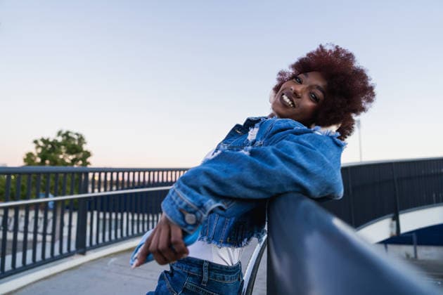 Smiling model with afro leaning on urban bridge at sunset model released, Symbolfoto property released, MRF02657