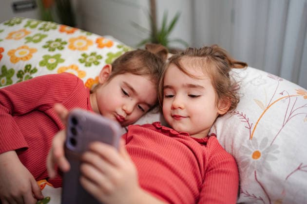 Junge Mädchen, die gemeinsam mit dem Smartphone Online-Inhalte entdecken Two young girls are sharing a smartphone, watching digital content at home (License=RF) ,model released, Symbolfoto Copyright: xZoonar.com JelenaxCvetkovicx 24901113 ,model released, Symbolfoto ,property released
