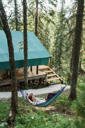 Serene camper resting in a hammock near Siberia glamping tent model released, Symbolfoto property released, VBUF00783