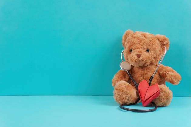 Teddybär mit Stethoskop und Herz auf blauem Hintergrund A teddy bear holding a stethoscope and a red heart on a blue surface, symbolizing pediatric care and emotional health. (License=RF) Copyright: xZoonar.com WICHAYADAxSUWANNACHUNx 24913600