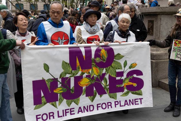 April 26, 2026, New York, New York, USA: Japanese and Korean survivors of the atomic bombings of Hiroshima and Nagasaki in August 1945 lead hundreds of anti-war advocates marching through the streets of midtown Manhattan to the United Nations after a rally against nuclear weapons at the New York Public Library (NYPL) on Fifth Avenue. Marchers hold a banner that reads NO NUKES FOR LIFE AND FOR PLANET. Demonstrators call on the United Nations and the delegates to the Nuclear Nonproliferation Treaty Review Conference, being held April 27 - May 22, to work toward a nuclear weapons-free world, abolish nuclear tests, phase out nuclear energy, provide reparations for indigenous peoples harmed by nuclear weapons production and testing, and to shi - ZUMAr174 20260426_znp_r174_036 Copyright: xGinaxMxRandazzox
