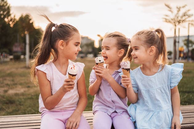 Drei kleine Mädchen, die bei Sonnenuntergang im Park ein Eis essen Three little girls enjoying ice cream cones together in a park at sunset (License=RF) ,model released, Symbolfoto Copyright: xZoonar.com JelenaxCvetkovicx 24959024 ,model released, Symbolfoto ,property released