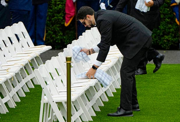 Chairs are dried off as a light rain falls before Britain s King Charles III and Queen Camilla are greeted by President Donald Trump and First Lady Melania Trump at an official welcoming ceremony at the White House in Washington DC on Tuesday, April 28, 2026. The king is on a four-day state visit to the U.S. and will stop in New York and Washington, where he will meet with U.S. officials and deliver an address to Congress.  WAP20260428901 BONNIExCASH