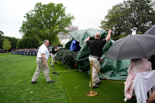 April 28, 2026, Washington, District Of Columbia, USA: Workers use tarps to cover the stage prior to the State arrival ceremony honoring King Charles III and Queen Camilla on the South Lawn of the White House in Washington, DC, USA, on April 28, 2026 in Washington, DC, USA Washington USA - ZUMAs152 20260428_faa_s152_004 Copyright: xYurixGripasx-xPoolxviaxCNPx