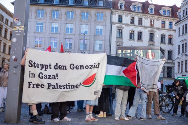 April 28, 2026, Leipzig, Saxony, Germany: A group of people hold a large banner reading Ã¢â‚¬oeStoppt den Genozid in Gaza! Free Palestine!Ã¢â‚¬Â alongside a Palestinian flag during a street protest in Leipzig due to the visit of the Isareli Ambassador Ron Prosor. Leipzig Germany  - ZUMAc291 20260428_zip_c291_003 Copyright: xMariaxCastrox