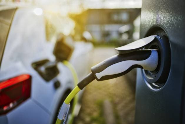E-Auto mit Ladekabel und Stromstecker an einer Ladesäule angeschlossen bei Sonnenaufgang im Gegenlicht in einem Wohngebiet an der Straße, Schagen, Nordholland, Niederlande E-car with charging cable and power plug connected to a charging station at sunrise in backlight in a residential area on the street, Schagen, North Holland, the Netherlands Copyright: imageBROKER JanxTepass ibxjte17367681.jpg