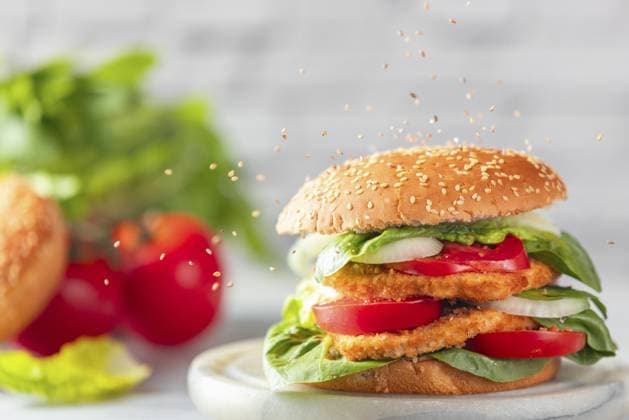 Sesam fällt auf Burger mit veganem Schnitzel, Tomaten, Zwiebel und Salat mit Zutaten im Hintergrund Sesame falls on burgers with vegan schnitzel, tomatoes, onions and salad with ingredients in the background Copyright: imageBROKER LucasxSeebacher ibxlse17381724.jpg