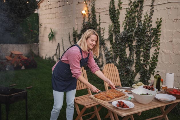 Ein fröhliches Sommertreffen mit Köstlichkeiten vom Grill und üppigem Grün Cook prepares a delicious spread outdoors amidst lush greenery and warm lights. (License=RF) ,model released, Symbolfoto Copyright: xZoonar.com JelenaxCvetkovicx 24972043 ,model released, Symbolfoto ,property released