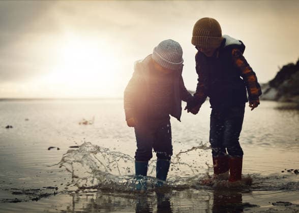Beach, sunset and silhouette of children in water splash together, holding hands and playing in waves. Fun, holiday and brothers, happy in boots on ocean vacation, jumping in sea on winter evening (License=RF) ,model released, Symbolfoto  Copyright: xZoonar.com YurixArcursxpeopleimages.comx 20001147 ,model released, Symbolfoto ,property released