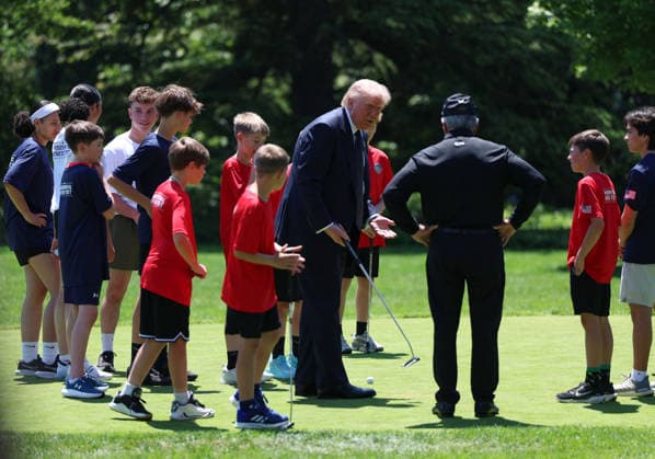 President Donald Trump gathers with children on the putting green on the South Lawn of the White House after he signed a proclamation inside the Oval Office at The White House in Washington, on May 5, 2026. The memorandum is set to restore the Presidential Fitness Test Award, a competitive school-based fitness program last seen under the Obama administration.  WASP20260505103 TomxBrenner