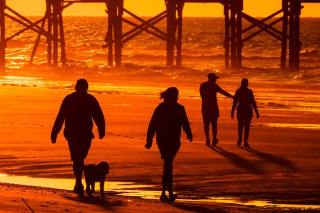 May 6, 2026, Isle Of Palms, Sc, United States: People walk along the beach silhouetted by the sunrise on a hazy morning along Front Beach, May 6, 2026 in Isle of Palms, South Carolina. Isle Of Palms United States - ZUMAe02_ 20260506_zaf_e02_001 Copyright: xRichardxEllisx