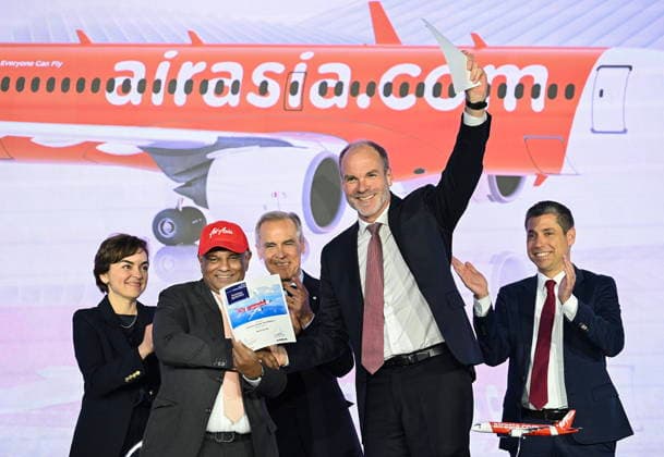 May 6, 2026, Mirabel, Pq, Canada: Quebec Premier Christine Frechette, left, Prime Minister Mark Carney, centre, and Guillaume Chevasson, CEO, Airbus Canada, right, look on as Lars Wagner, CEO, Airbus Commercial Aircraft, front right, shakes hands with AirAsia CEO Tony Fernandes during an event at the Airbus A220 Delivery Center in Mirabel, Que., Wednesday, May 6, 2026, where AirAsia placed a landmark order for 150 Airbus A220 aircraft. Mirabel Canada - ZUMAc35_ 20260506_zaf_c35_134 Copyright: xGrahamxHughesx