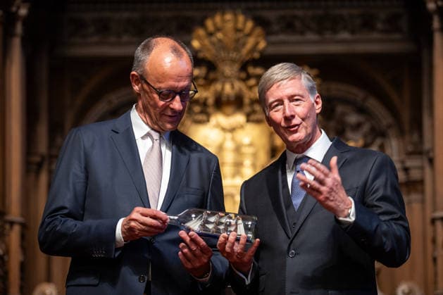 Friedrich Merz, Bundeskanzler, nach seiner Festrede im Hamburger Rathaus, mit Harald Vogelsang, Präsident Übersee-Club und Vorstandsvorsitzender Hamburger Sparkasse bei der Übergabe eines Buddelschiffs als traditionelles Gastgeschenk;76. Großer Übersee-Tag in Hamburg, April 2026 Festakt im Hamburger Rathaus, Hamburg Hamburg Deutschland Rathaus *** Friedrich Merz, Federal Chancellor, after his speech at Hamburg City Hall, with Harald Vogelsang, President of the Overseas Club and Chairman of the Board of Hamburger Sparkasse, at the presentation of a ship in a bottle as a traditional gift 76 Great Overseas Day in Hamburg, April 2026 Ceremony at Hamburg City Hall, Hamburg Hamburg Germany City Hall