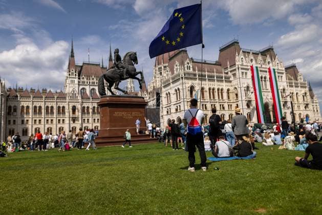 News Bilder des Tages May 9, 2026, Budapest, Hungary: A man holding a European Union flag listens to speeches broadcast on large screens among crowds gathered at Lajos Kossuth Square during the inauguration of Peter Magyar in Budapest. Budapest Hungary - ZUMAl194 20260509_zip_l194_003 Copyright: xMarekxLadzinskix