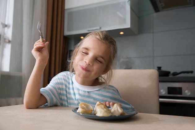 IMAGO Creative, Food, Dumplings Ein achtjähriges Mädchen genießt es, zu Hause in der Küche zum Mittagessen Knödel zu essen An eight-year-old girl enjoys eating dumplings for lunch at home in the kitchen (License=RF) ,model released, Symbolfoto Copyright: xZoonar.com UliaxZotaninax 25039455 ,model released, Symbolfoto ,property released