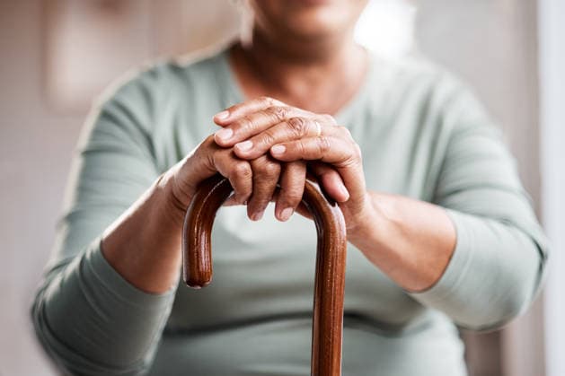 Home, hands and senior woman with cane for mobility support, dementia and gait change. Pensioner, elderly person with disability and walking aid in retirement for balance, alzheimer and assistance. model released property released Copyright: xwww.peopleimages.comx