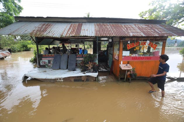 Aftermath of flood in Sumatra TANAH DATAR, INDONESIA - MAY 13: A Resident walks through a flood area in Tanah Datar, West Sumatera Province, Indonesia on May 13, 2026. The structures affected by the floods include residential homes, vehicle, irrigation dam, two village bridge, subdistrict roads, and the rice field. Adi Prima Anadolu Tanah Datar Indonesia. Editorial use only. Please get in touch for any other usage.  Copyright: x2026xAnadoluxAdixPrimax
