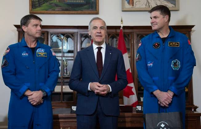 May 13, 2026, Ottawa, On, Canada: Artemis II mission astronaut Jeremy Hansen, right, and Commander Reid Wiseman look on as Prime Minister Mark Carney speaks during an event in Ottawa, Wednesday, May 13, 2026. Ottawa Canada  - ZUMAc35_ 20260513_zaf_c35_009 Copyright: xAdrianxWyldx