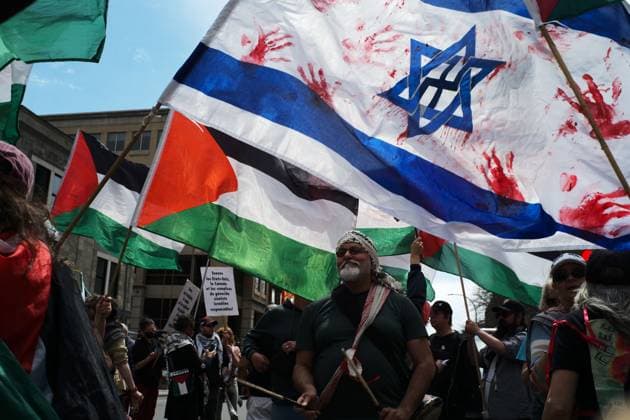 May 16, 2026, Montreal, Canada: A pro-Palestinian demonstrator playing drums in front of an Israel flag drenched in fake blood. On the 16th of May 2026, members of the Palestinian community and allies in Montreal commemorated the 78th Nakba, which translates to catastrophy in Arabic and resulted in the ethnic cleansing and displacement of at least 750,000 Palestinians and the foundation of the State of Israel in 1948. This is an annual demonstration, and they demanded the end of the Zionist government and the ongoing offensive against Gaza. Montreal Canada - ZUMAs197 20260516_aaa_s197_517 Copyright: xGiordannoxBrumasx