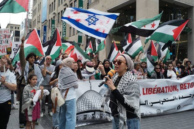 May 16, 2026, Montreal, Canada: A pro-Palestian demonstrator giving a speech in front of the march on Saint Catherine street. On the 16th of May 2026, members of the Palestinian community and allies in Montreal commemorated the 78th Nakba, which translates to catastrophy in Arabic and resulted in the ethnic cleansing and displacement of at least 750,000 Palestinians and the foundation of the State of Israel in 1948. This is an annual demonstration, and they demanded the end of the Zionist government and the ongoing offensive against Gaza. Montreal Canada - ZUMAs197 20260516_aaa_s197_500 Copyright: xGiordannoxBrumasx