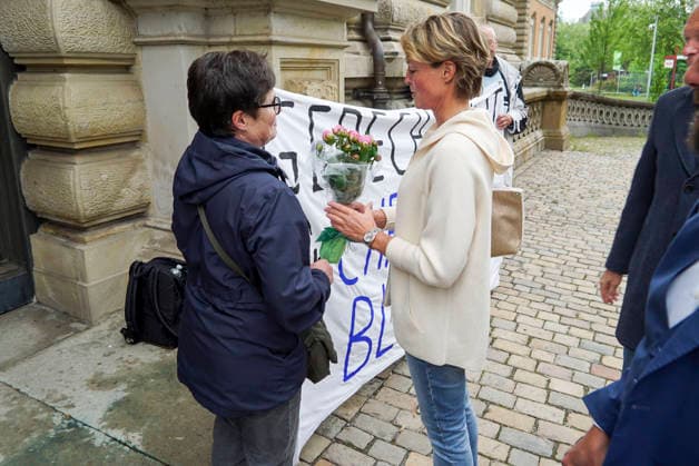 CNTV BLOCK- Unterstuetzer von Frau Block ubergeben einen Blumenstrauss an die Angeklagte mit dem Transparent Aufschrift Gerechtigkeit fuer Christina Block, Christina Block Unternehmerin mit ihren Verteidiger Ingo Bott stehen vom Gericht auf der Strasse 20.05.2026 beim Prozess wegen mutmasslicher Kindesentfuehrung im Landgericht Hamburg Strafjustizgebaeude Entfuehrungsfall der Block Kinder Hamburg Deutschland *** CNTV BLOCK Supporters of Ms. Block hand over a bouquet of flowers to the defendant with the banner inscription Justice for Christina Block, Christina Block entrepreneur with her defense lawyer Ingo Bott stand from the court on the street 20 05 2026 at the trial for alleged child abduction in the district court of Hamburg criminal j