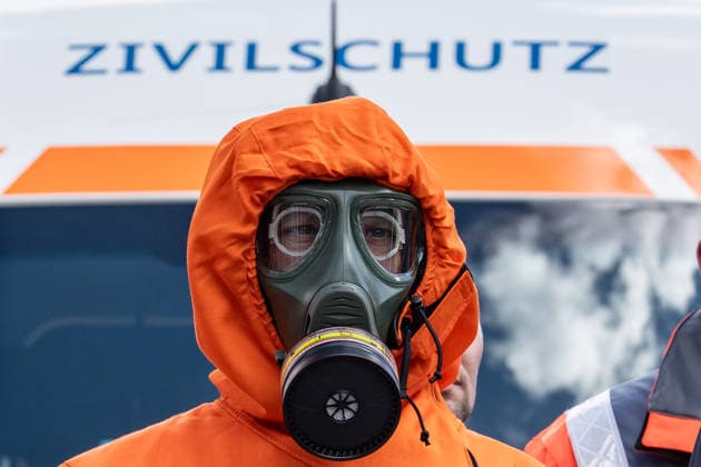 Person mit Schutzanzug und Atemschutzmaske vor einem Fahrzeug dfes Ziviklschutzes;Vorstellung Pakt für den Bevölkerungsschutz durch Bundesinnenminister und Verteidigungsminister mit Übergabe von 13 Einsatzfahrzeugen an den Zivilschutz, Berlin Berlin Deutschland Hauptbahnhof, Washingtonplatz *** Person with protective suit and breathing mask in front of a civil defense vehicle Presentation of the Civil Protection Pact by the Federal Minister of the Interior and the Minister of Defense with handover of 13 emergency vehicles to the civil defense, Berlin Berlin Germany Central Station, Washingtonplatz