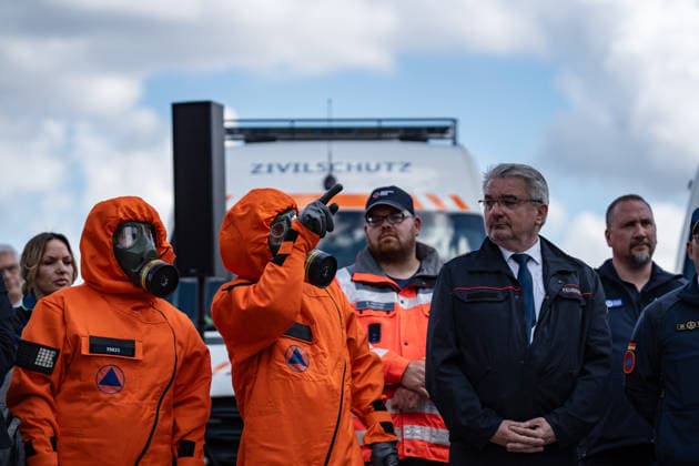Person mit Schutzanzug und Atemschutzmaske vor einem Fahrzeug dfes Ziviklschutzes;Vorstellung Pakt für den Bevölkerungsschutz durch Bundesinnenminister und Verteidigungsminister mit Übergabe von 13 Einsatzfahrzeugen an den Zivilschutz, Berlin Berlin Deutschland Hauptbahnhof, Washingtonplatz *** Person with protective suit and breathing mask in front of a civil defense vehicle Presentation of the Civil Protection Pact by the Federal Minister of the Interior and the Minister of Defense with handover of 13 emergency vehicles to the civil defense, Berlin Berlin Germany Central Station, Washingtonplatz