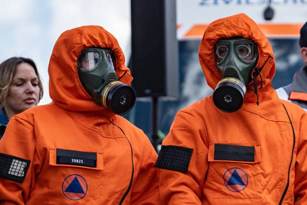 Person mit Schutzanzug und Atemschutzmaske vor einem Fahrzeug dfes Ziviklschutzes;Vorstellung Pakt für den Bevölkerungsschutz durch Bundesinnenminister und Verteidigungsminister mit Übergabe von 13 Einsatzfahrzeugen an den Zivilschutz, Berlin Berlin Deutschland Hauptbahnhof, Washingtonplatz *** Person with protective suit and breathing mask in front of a civil defense vehicle Presentation of the Civil Protection Pact by the Federal Minister of the Interior and the Minister of Defense with handover of 13 emergency vehicles to the civil defense, Berlin Berlin Germany Central Station, Washingtonplatz