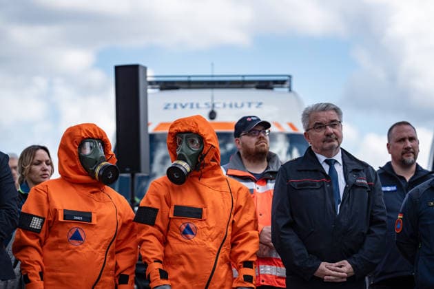 Person mit Schutzanzug und Atemschutzmaske vor einem Fahrzeug dfes Ziviklschutzes;Vorstellung Pakt für den Bevölkerungsschutz durch Bundesinnenminister und Verteidigungsminister mit Übergabe von 13 Einsatzfahrzeugen an den Zivilschutz, Berlin Berlin Deutschland Hauptbahnhof, Washingtonplatz *** Person with protective suit and breathing mask in front of a civil defense vehicle Presentation of the Civil Protection Pact by the Federal Minister of the Interior and the Minister of Defense with handover of 13 emergency vehicles to the civil defense, Berlin Berlin Germany Central Station, Washingtonplatz