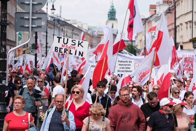 May 20, 2026, Warsaw, Masovian Voivodeship, Poland: A protester carries a sign that reads Tusk, go to Berlin in German as thousands march down Warsaw s Nowy Swiat Street during a protest march against the European UnionÃ¢â‚¬â ¢s green policies and in support of a national referendum on the EU Green Deal. Organized by the trade union Solidarity, which has close ties to the Law and Justice (PiS) party, the demonstration was mostly right-wing, anti-EU, and anti-government in character. Warsaw Poland  - ZUMAk204 20260520_zip_k204_030 Copyright: xRomanxKozielx
