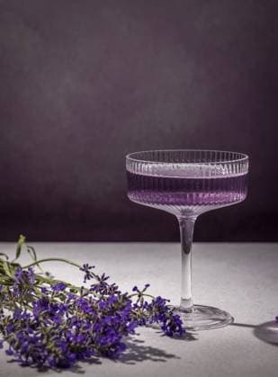 Eleganter Lavendelcocktail, serviert in einem stilvollen Glas, begleitet von frischen Lavendelblüten, die eine raffinierte und erfrischende Atmosphäre schaffen Elegant lavender cocktail served in a stylish glass, accompanied by fresh lavender flowers that create a sophisticated and refreshing atmosphere Copyright: imageBROKER VictoriaxKondysenko ibxiqx17660430.jpg
