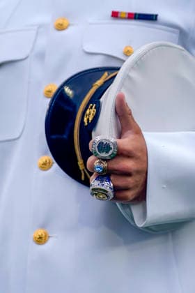 A midshipmen wearing rings carries his cap while processing during the U.S. Naval Academy Graduation and Commissioning Ceremony at the U.S. Naval Academy in Annapolis, Maryland on Friday, May 22, 2026. The Naval Academy has a total of 1059 graduates.  ANN20260522300 BONNIExCASH