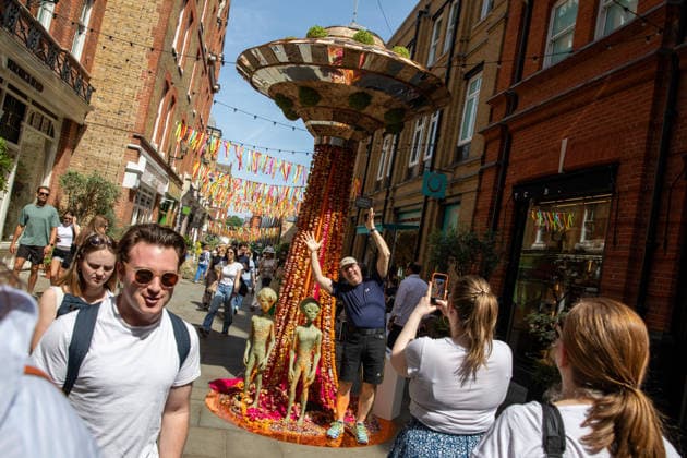 May 22, 2026, London, United Kingdom: Members of the public pose for photographs in-front of floral displays during the RHS Chelsea Flower Show. After several days of unsettled weather, large crowds gathered along Sloane Street and the surrounding areas on the penultimate day of the 2026 RHS Chelsea Flower Show to view the elaborate floral displays created for the annual event. Visitors lined the streets of Chelsea as retailers, hotels and restaurants unveiled large-scale made from fresh flowers and plants, continuing a tradition that has become closely associated with the world-famous horticultural show. London United Kingdom - ZUMAs197 20260522_aaa_s197_010 Copyright: xJamesxWilloughbyx