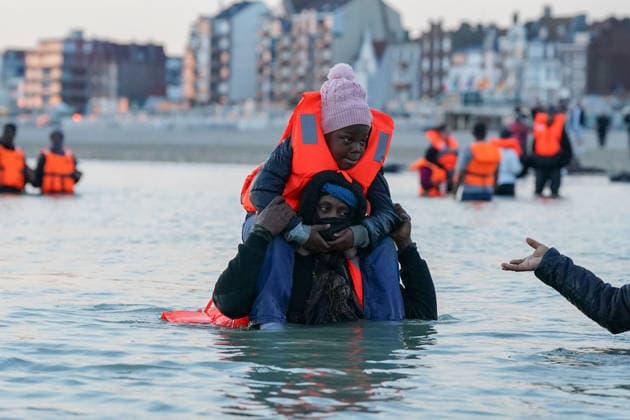 May 23, 2026, Dunkirk, Nord, France: Dunkirk, France. A migrants carrying a child, standing in the sea at the beach at Dunkirk, while attempting to cross the English Channel. More than 200,000 migrants have crossed the Channel in small boats since 2018. Dunkirk France  - ZUMAl94_ 20260523_zaf_l94_025 Copyright: xIoannisxAlexopoulosx