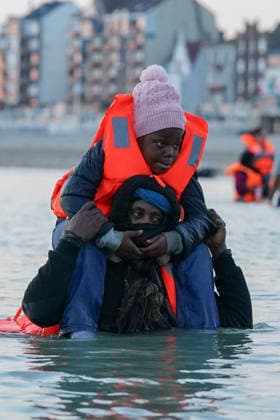 May 23, 2026, Dunkirk, Nord, France: Dunkirk, France. A migrants carrying a child, standing in the sea at the beach at Dunkirk, while attempting to cross the English Channel. More than 200,000 migrants have crossed the Channel in small boats since 2018. Dunkirk France  - ZUMAl94_ 20260523_zaf_l94_029 Copyright: xIoannisxAlexopoulosx