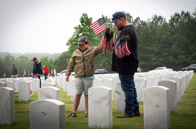 May 23, 2026, Canton, Georgia, USA: A father and son join scores of volunteers to place U.S. flags on veteransÃ¢â‚¬â ¢ graves during Memorial Day celebration at the Georgia National Cemetery. Canton USA  - ZUMAn03_ 20260523_zaf_n03_004 Copyright: xRobinxRaynex